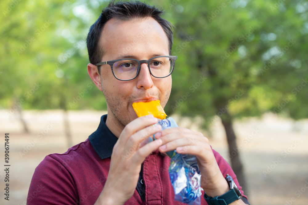 Fototapeta premium man eating icecream at the park wearing glasses