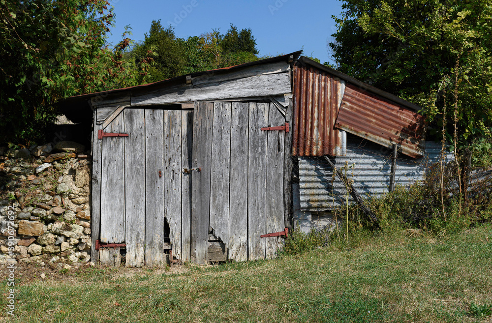 old weathered wooden barn with rusty iron plates