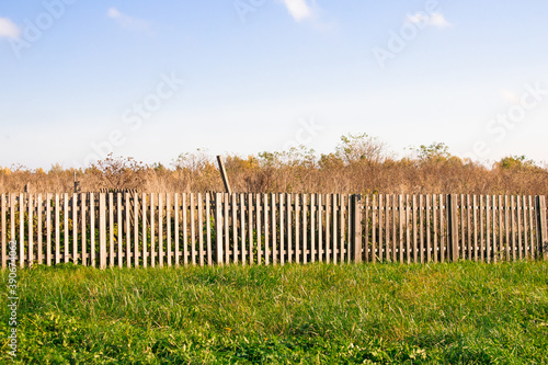 Rural landscape with wooden fence, sky and grass