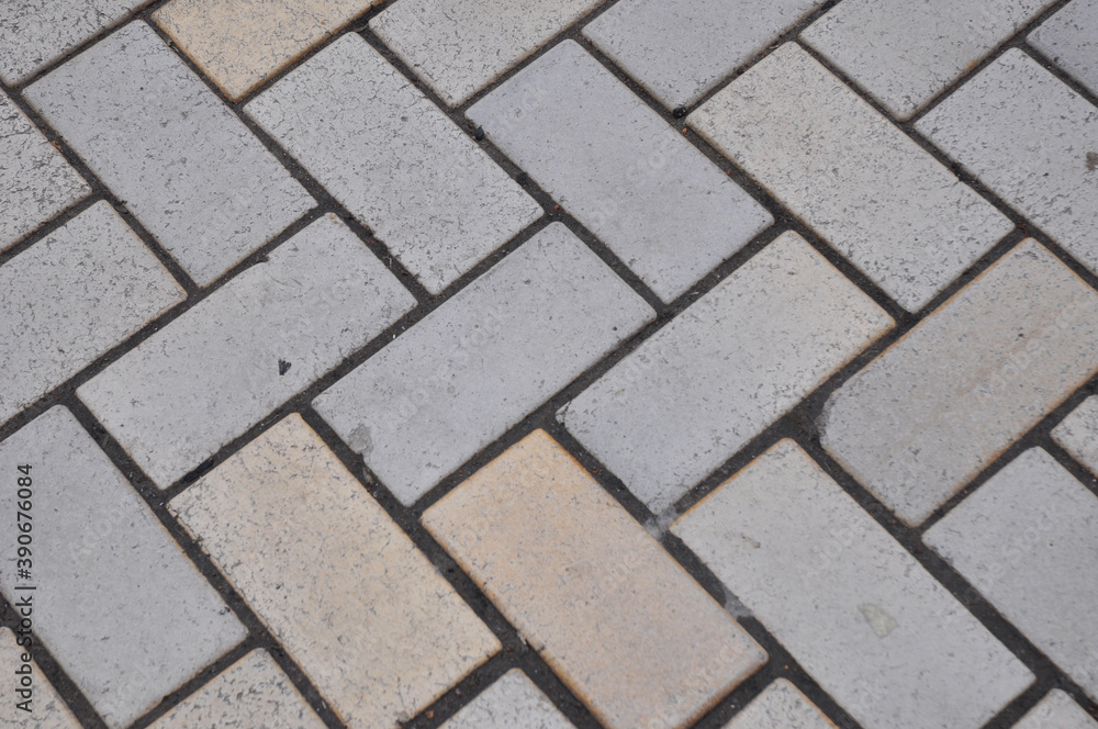 A close up of a paving herringbone pattern background as a common paver pattern for driveways. A close up of a paving herringbone pattern background as a common paver pattern for driveways.