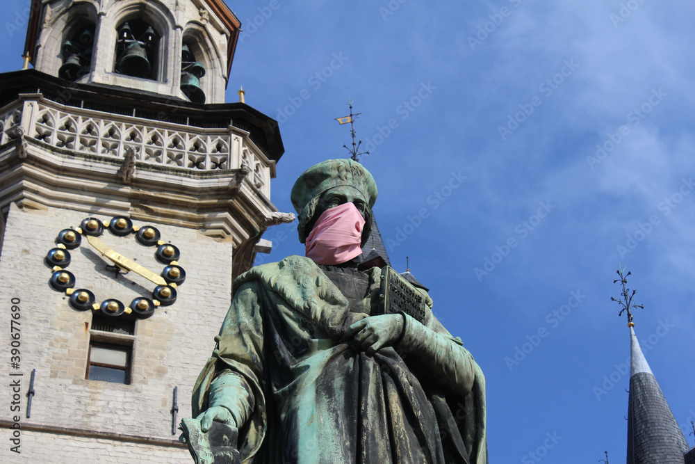 The Aalst landmark statue of Dirk Martens wearing a mouth mask. A humorous reminder to locals to comply with COVID 19 regulations and to wear a face covering.