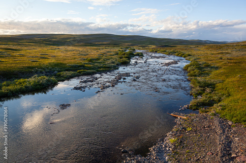 Fototapeta Naklejka Na Ścianę i Meble -  Rivulet flows through tundra on mountain plateau, Varanger national scenic route, Finnmark, Norway
