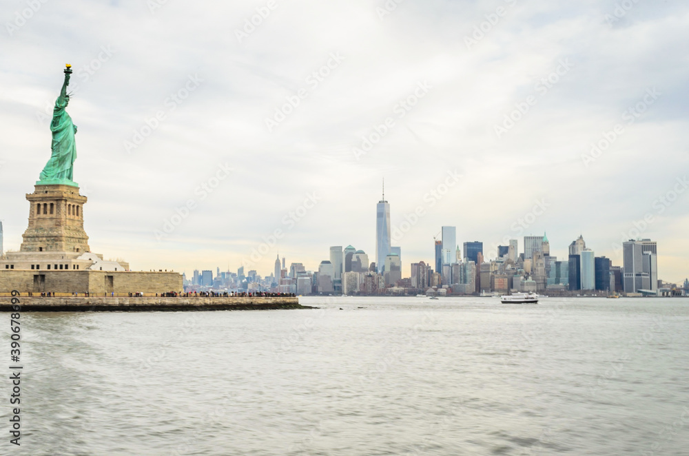 Fototapeta premium Lady Liberty Statue with Lower Manhattan Futuristic Buildings and Towers in Background . New York City, USA