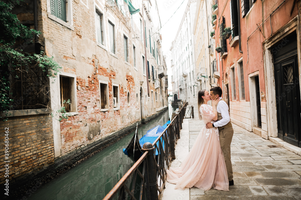 Romantic, fairytale, happy newlywed couple hugging and kissing in Venice, Italy