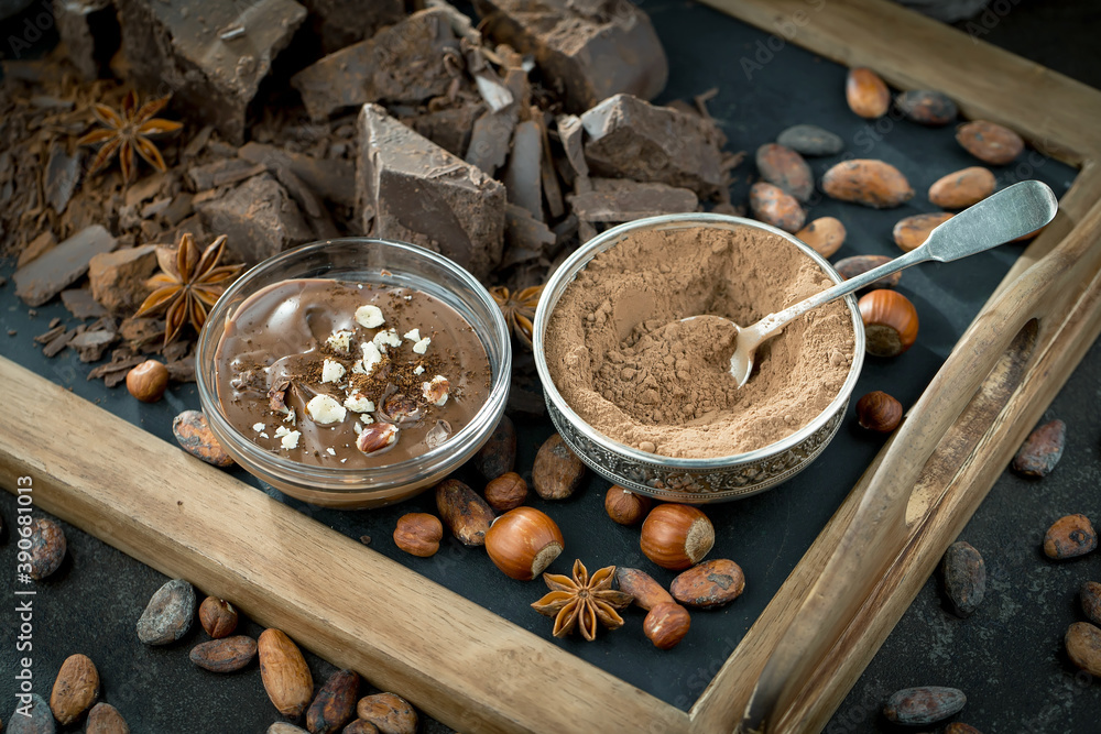 Dark chocolate in a composition with cocoa beans and nuts, on an old background. Dark chocolate in a composition with cocoa beans and nuts, on an old background.