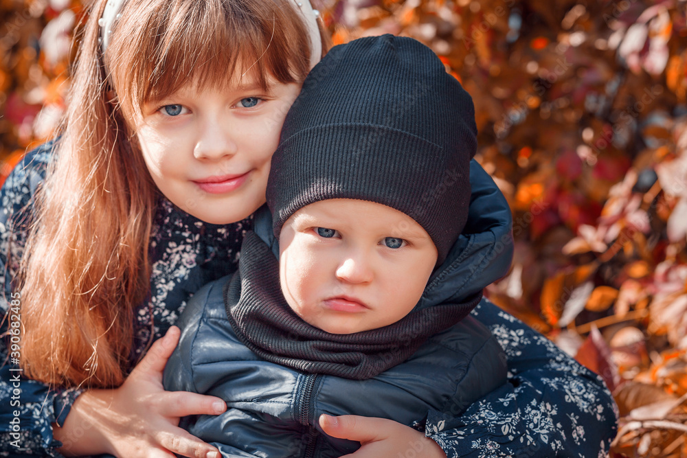 Young children hugging. A little girl hugs her little brother. Children in warm clothes Young children hugging. A little girl hugs her little brother. Children in warm clothes