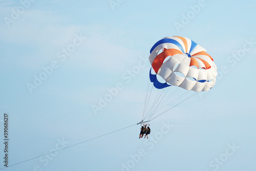  Parasailing. Parachute with passengers against the blue sky. The concept of the popular extreme - entertainment.