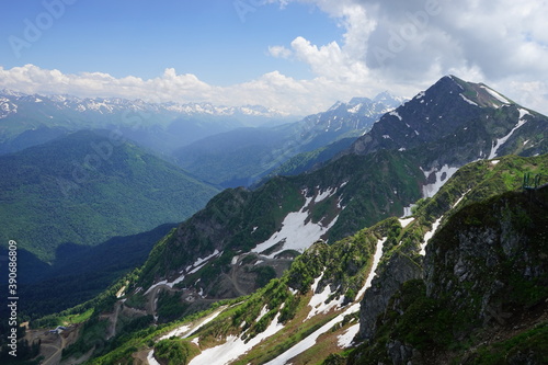 beautiful green mountains with snow on a background of clouds. Rosa Khutor . Summer