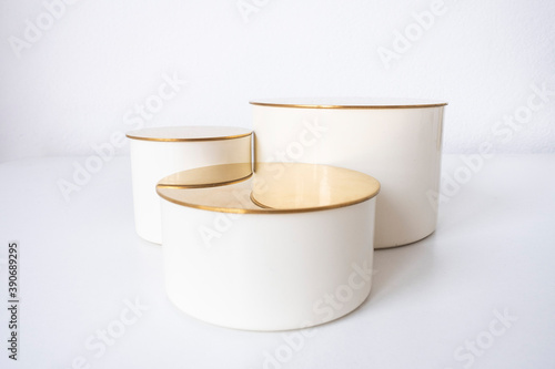 Obraz na plátně three beige cylinder podiums with golden tops of different heights on a white background