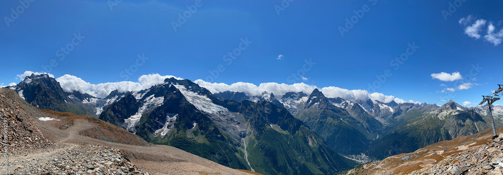 mountain panorama with blue sky and mountain peaks in snow on a clear summer day,, copy space