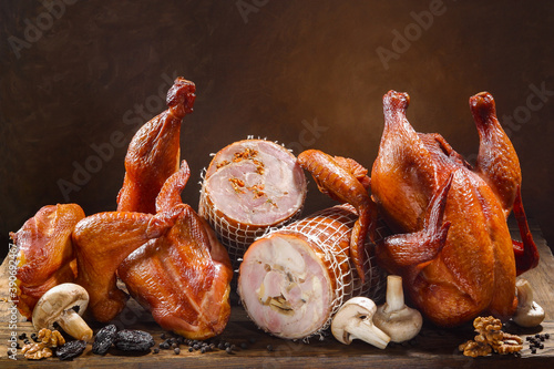 A variety of products made from smoked chicken including roll with mushrooms, nuts, prunes, black pepper and fresh vegetables