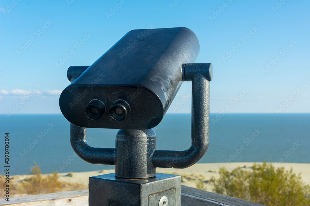Public binoculars in an anti-vandal case. Coin-operated binocular viewer for sea tourists