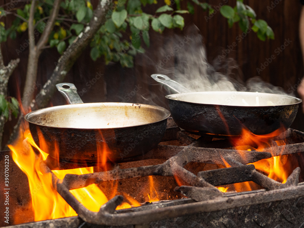 frying pan on a bright fire. cooking over a fire. burning bonfire frying pan on a bright fire. cooking over a fire. burning bonfire