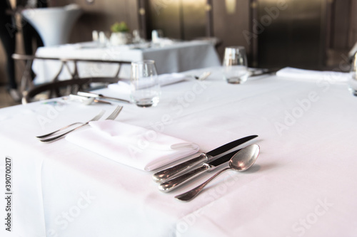 Dinner setting. Silver fork and knife on table. Restaurant interior
