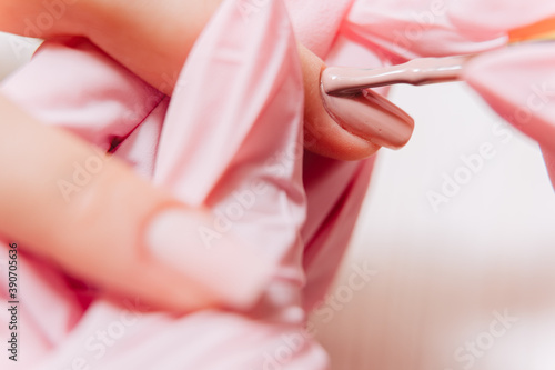 Manicure process. Manicurist paints fingernails. Nail polish.