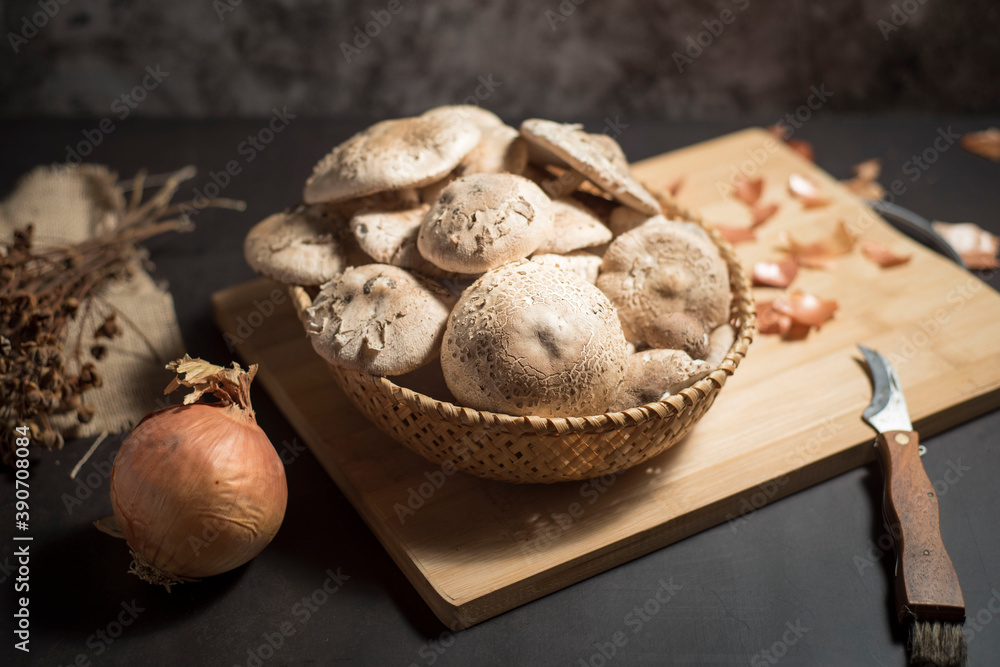 Closeup of fresh white mushrooms in a basket on a wooden cutting board Closeup of fresh white mushrooms in a basket on a wooden cutting board