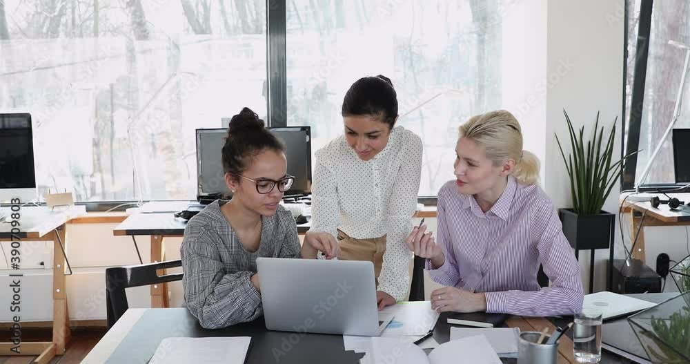 Interested young african american female worker discussing online project or corporate application with indian and european colleagues. Happy diverse partners developing business strategy in office. Interested young african american female worker discussing online project or corporate application with indian and european colleagues. Happy diverse partners developing business strategy in office.
