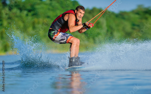 Wakeboarder surfing across a lake © Mark_studio