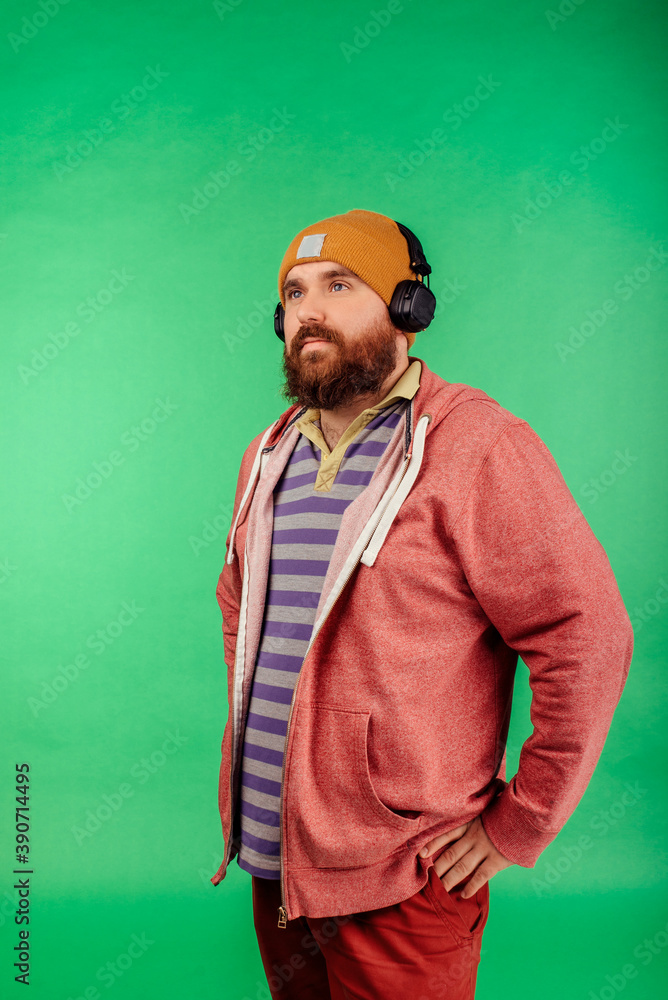 close-up of caucasian man wearing headphones on green studio background close-up of caucasian man wearing headphones on green studio background