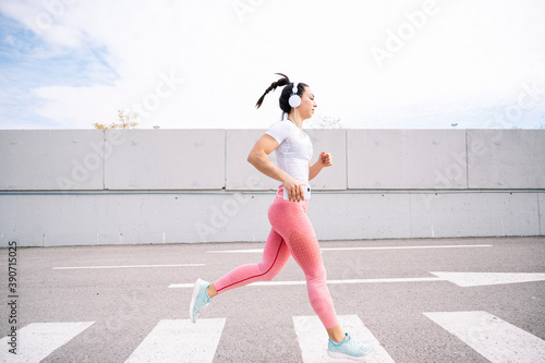 Running girl in the street with headphones