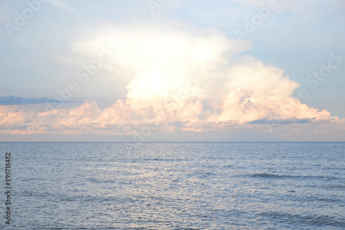 Sunset behind the clouds on the sea in summer
