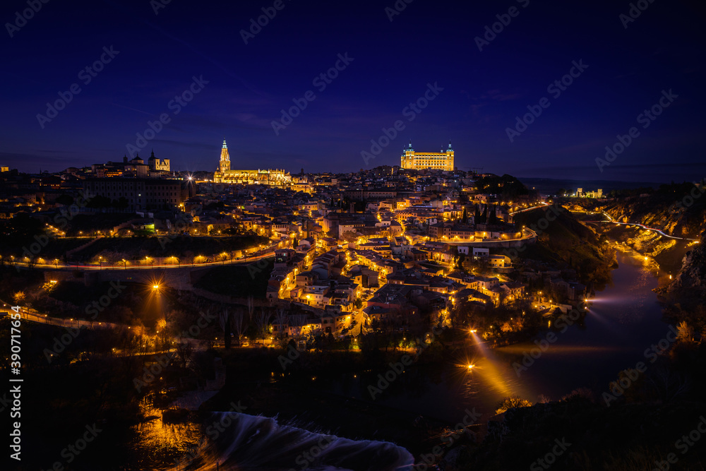 Beautiful view of Toledo city skyline with Cathedral, Alcazar and Tagus river at night, Spain