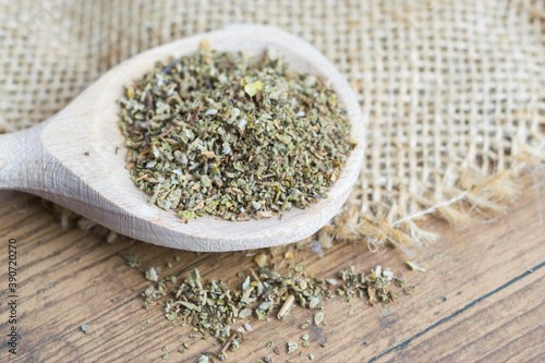 Dry, finely ground cistus leaves, herbal tea on wooden spoon