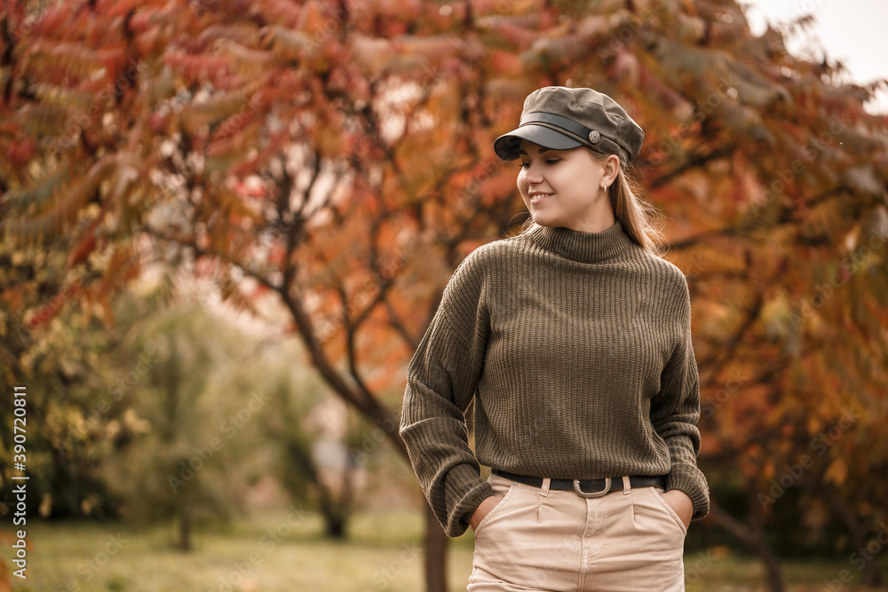 Young beautiful girl dressed in stylish clothes, green sweater and beige pants, in an autumn park with beautiful trees Young beautiful girl dressed in stylish clothes, green sweater and beige pants, in an autumn park with beautiful trees