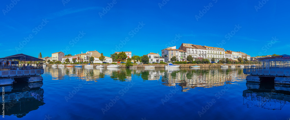 Panorama view of Herault river at the town Agde with buildings and boats, Languedoc-Roussillon France