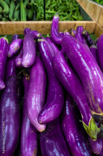 A crate of eggplants in the grocery store's vegetable section