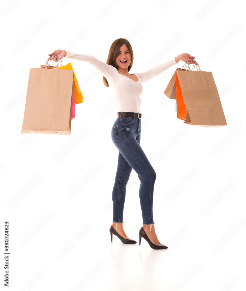Brunette smiles and holds packages with good shopping. Beautiful girl rejoice after a successful shopping. Brunette smiles and holds packages with good shopping. Beautiful girl rejoice after a successful shopping.