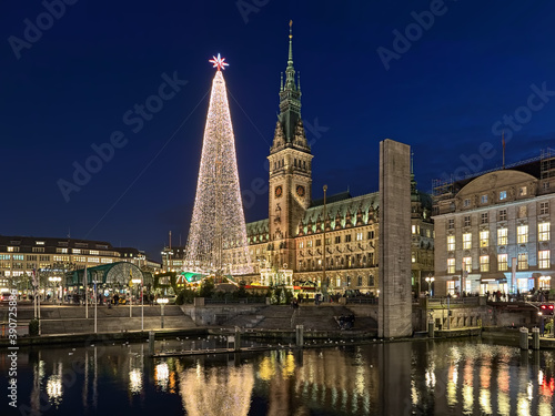 Obraz na płótnie Hamburg, Germany. Christmas market with large illuminated Christmas tree at Town Hall square in front of Hamburg Town Hall in dusk. View from Alsterarkaden at Kleine Alster river. w salonie