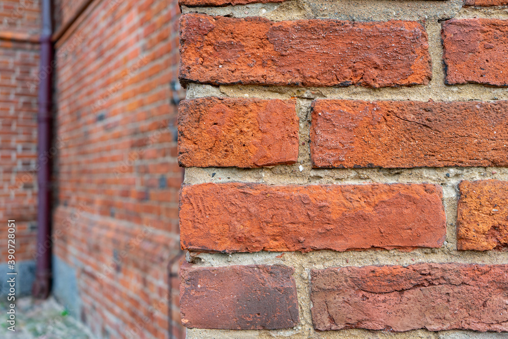 An old red brick wall with a rough cement seam An old red brick wall with a rough cement seam