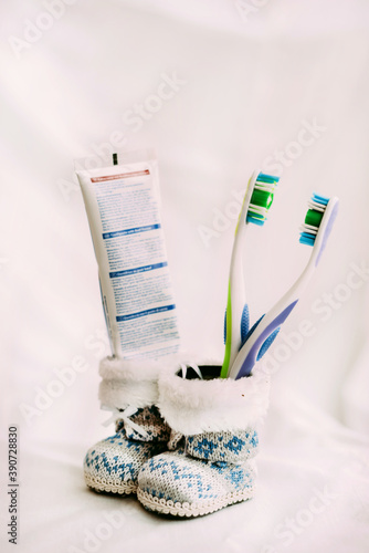 Close-up of boots with decorative with blurred toothbrushes and toothpaste on a white background. Oral hygiene care concept.