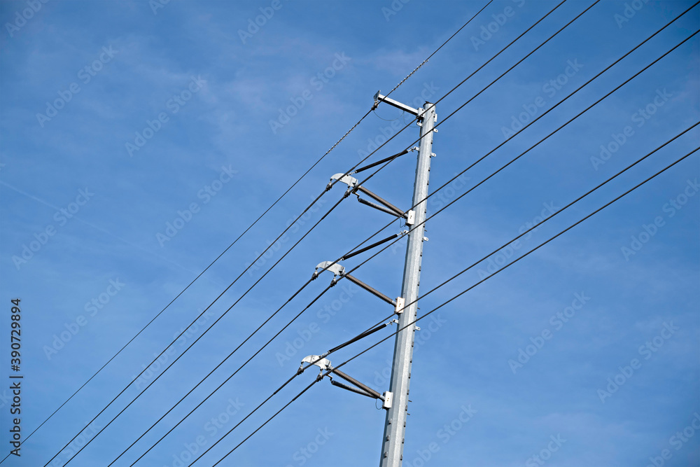 Electrical power lines and metal pole against a blue sky. Electrical power lines and metal pole against a blue sky.