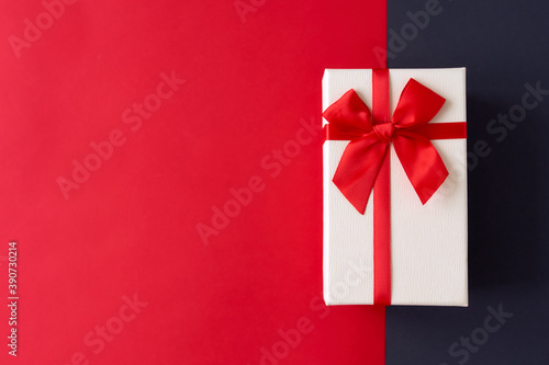 White present with red ribbon on the bright red background