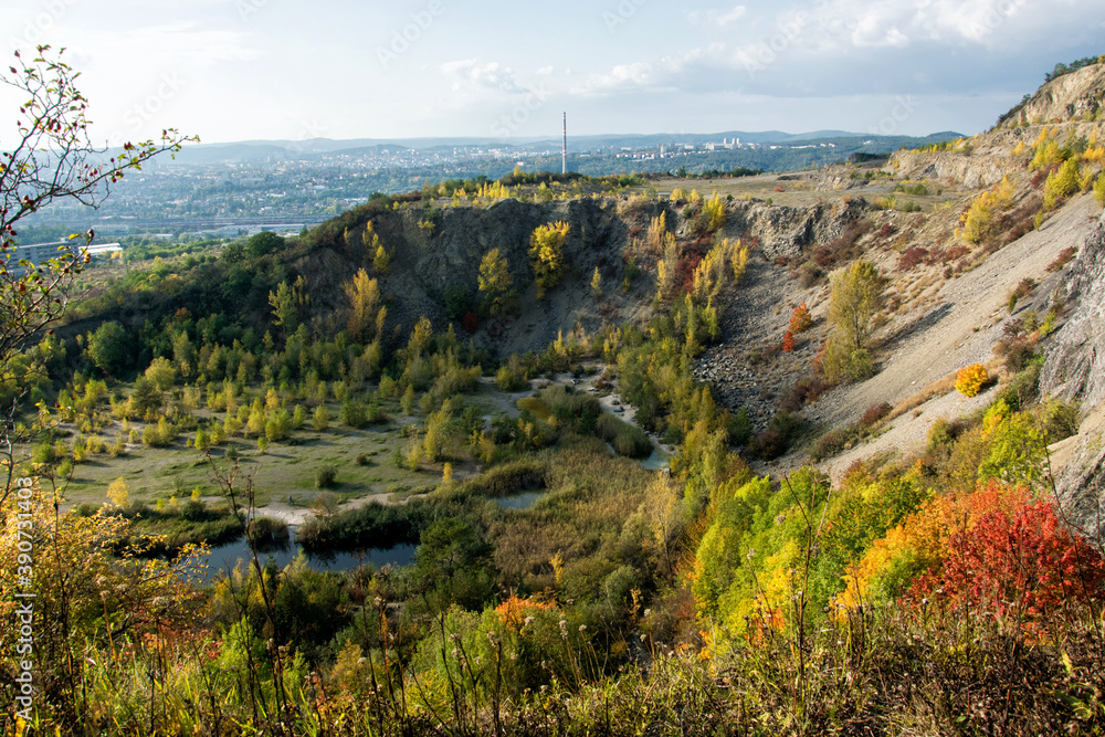Old abandoned quarry in autumn. In the background you can see the city of Brno, Czech Republic