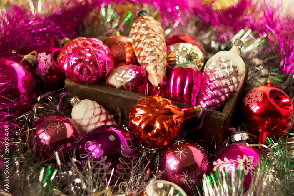 Old New Year's toys from the USSR times in the form of cones, snowflakes. Christmas pink, crimson and red toys on the Christmas tree and silver tinsel in a wooden box