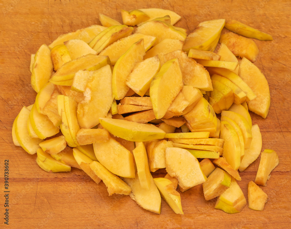 Sliced quince on a wooden background. in the process of cooking quince jam Sliced quince on a wooden background. in the process of cooking quince jam