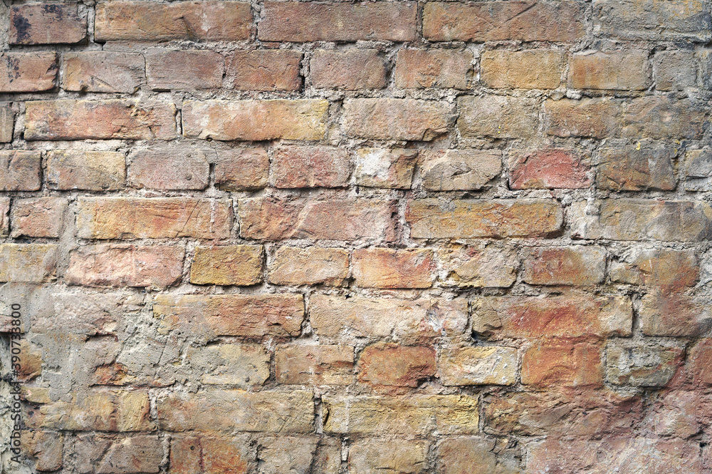 Fototapeta premium Antique wall texture with exposed old bricks battered by time in grunge and vintage style