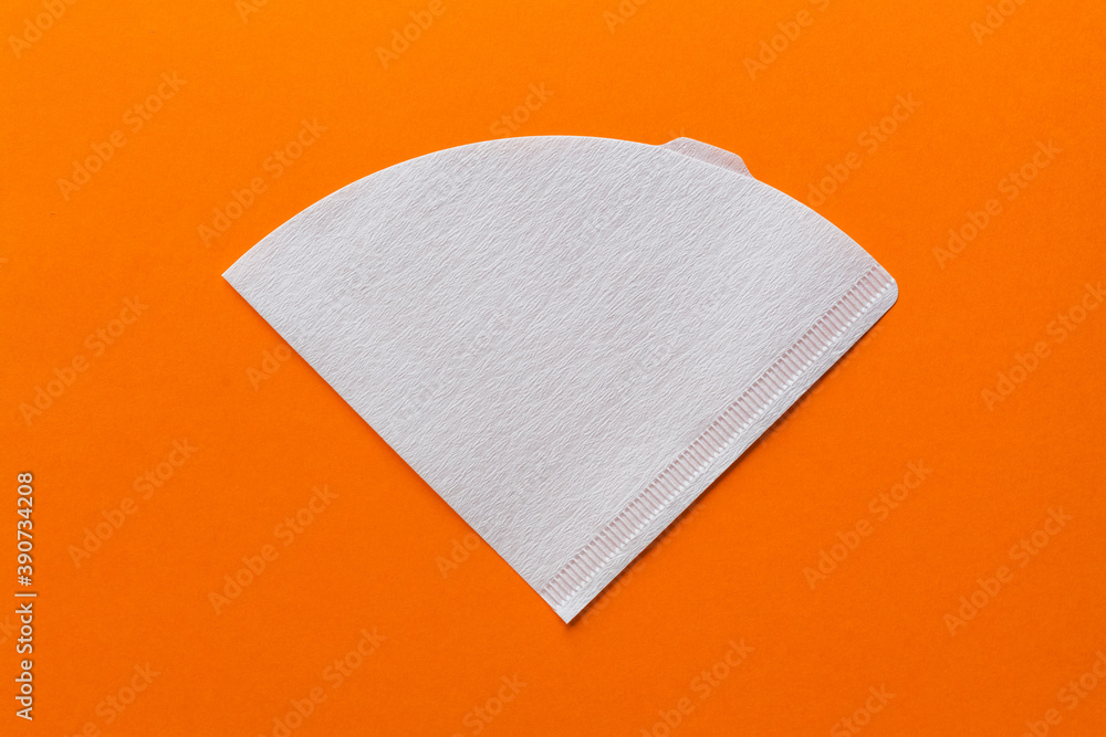 Bleached paper coffee filter isolated on a colored orange background