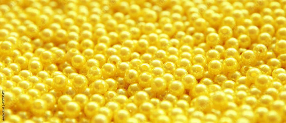many yellow beads of yellow color on the surface of a dense background, full frame, selected sharpness many yellow beads of yellow color on the surface of a dense background, full frame, selected sharpness