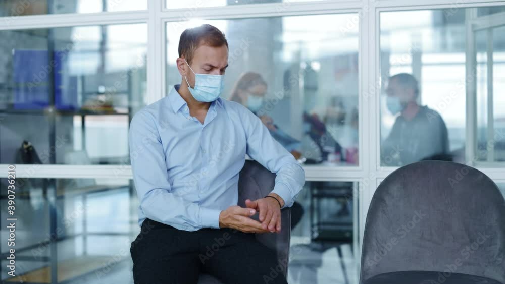 Young man with face medical mask waiting in hospital looking around in modern room. Quarantine protection pandemic corona epidemic. Slow motion Young man with face medical mask waiting in hospital looking around in modern room. Quarantine protection pandemic corona epidemic. Slow motion
