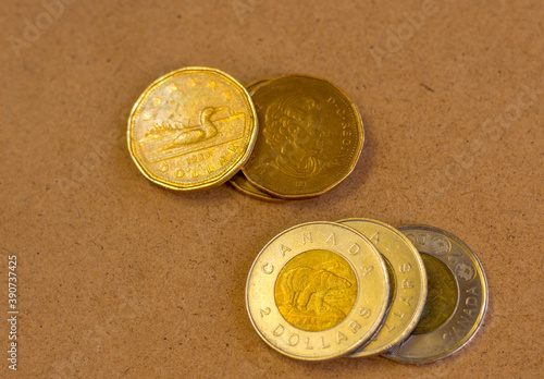 Canadian currency with a yellowish background. Pile of Golden coin, copper coin, Various Canadian coins, 