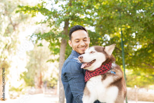 Latin adult man with a husky puppy in his arms