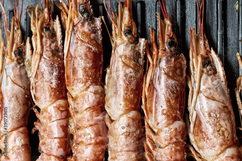 red langoustine heads background, lie vertical row close up on grill toned design