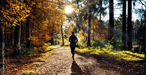 Female Runner in Silent Forest in spring with beautiful bright sun rays