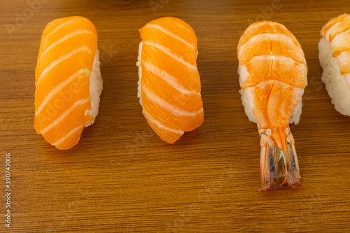 sushi with salmon steamed nigiri and shrimp close-up on a wooden background photo