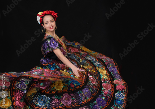 Tela mujer chiapaneca con vestido floreado bordado a mano y rebozo naranja, bailando