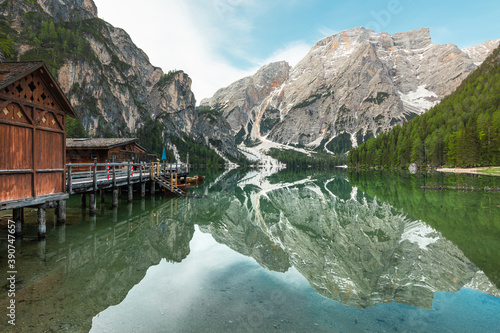 Mount Seekofel and boatshouse mirroring in the clear calm water of iconic mountain lake Pragser Wildsee (Lago di Braies) in Dolomites, Unesco World Heritage, South Tyrol, Italy